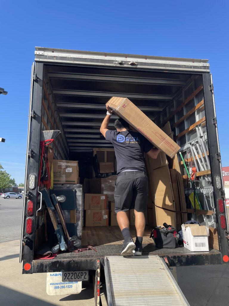 Mover loading a large box into a moving truck