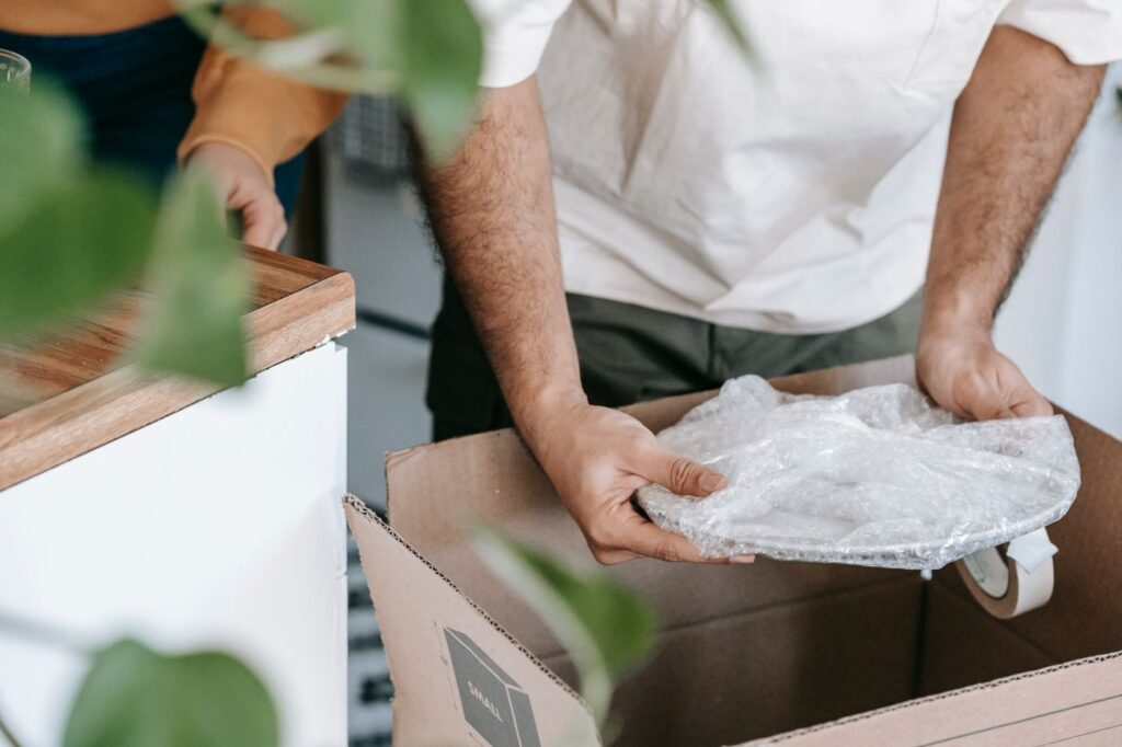 Placing a paper-wrapped plate into a moving box