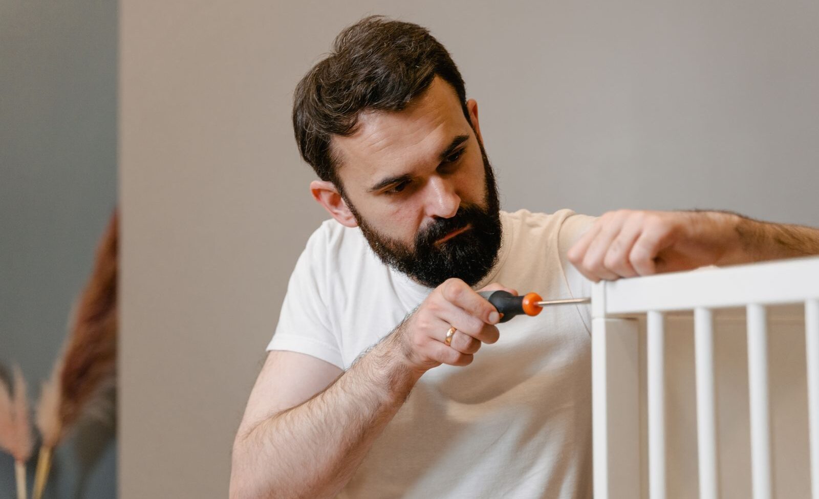Assembling a crib with a screwdriver during a move